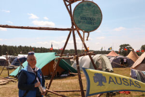 Johanna står under en skylt med texten "KFUM Härnösand Scoutkår"