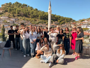 En gruppbild på alla deltagarna under Emma-utbildningen med bergsstaden Berat i bakgrunden. 